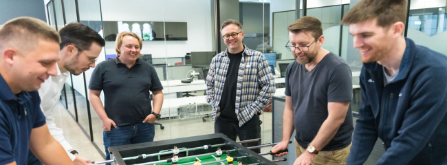 The NurtureCloud team playing foosball in the office